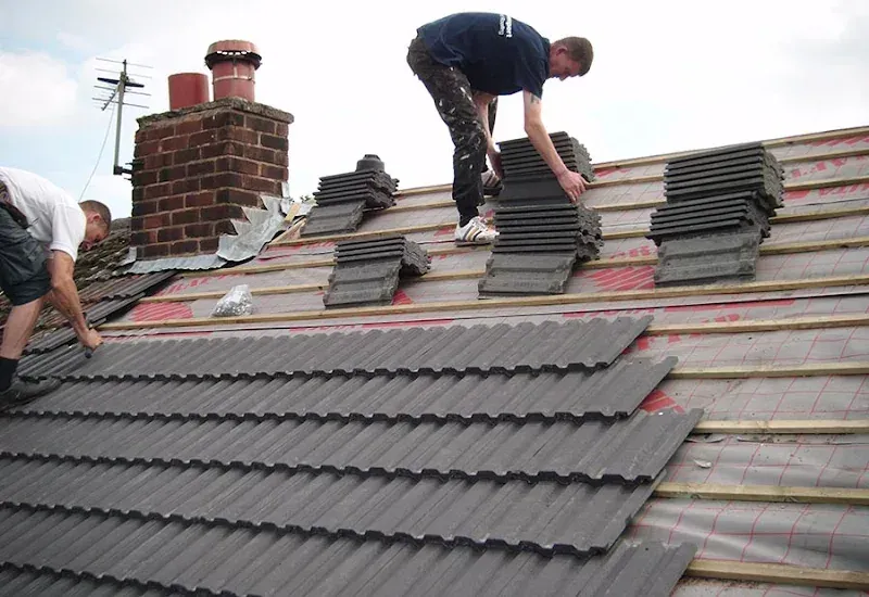 {client name} roofers installing new grey concrete tiles on a {service area} property